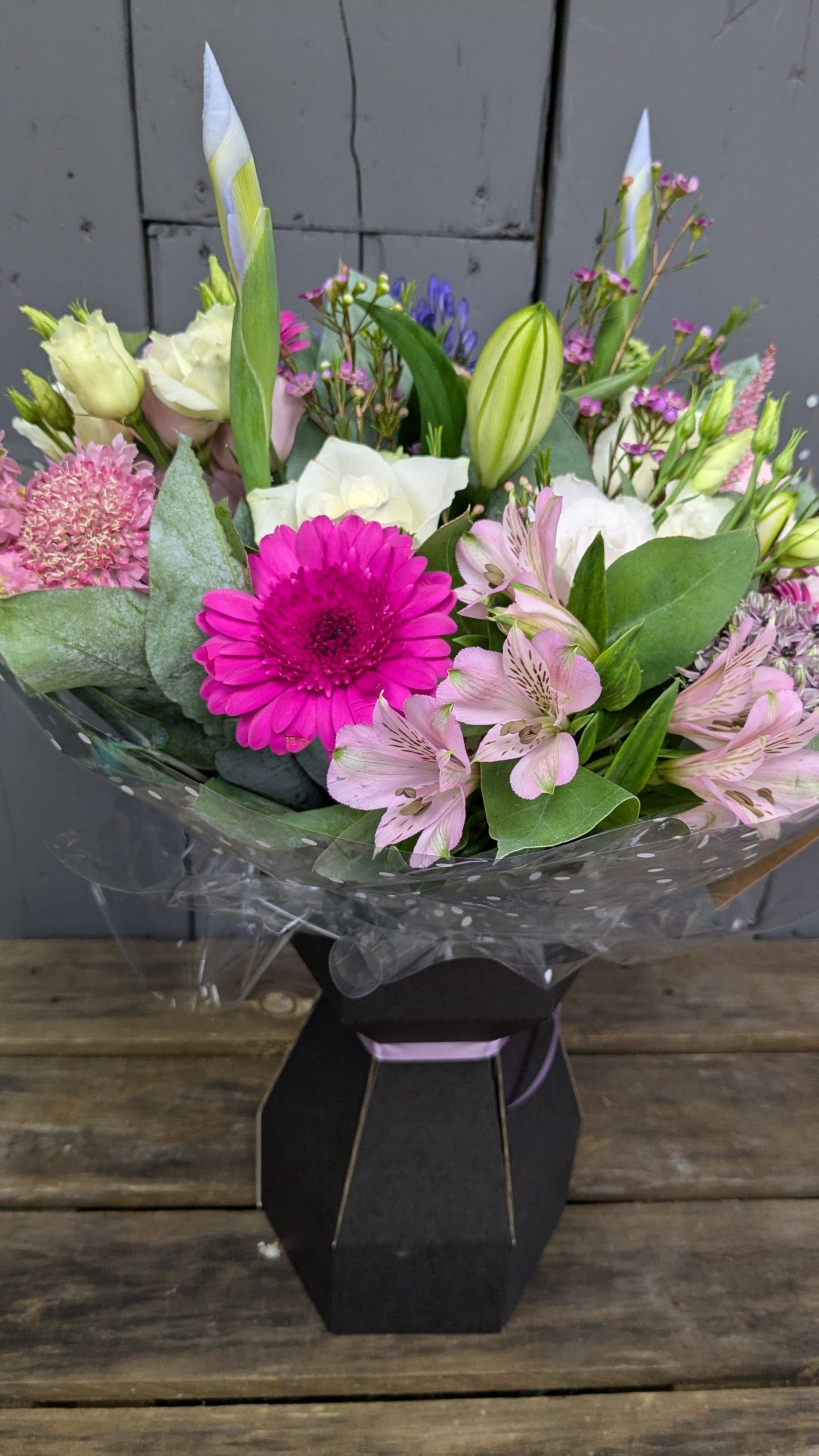 florist choice bouquet of flowers with bright pink and purple colours, lilies and foliage